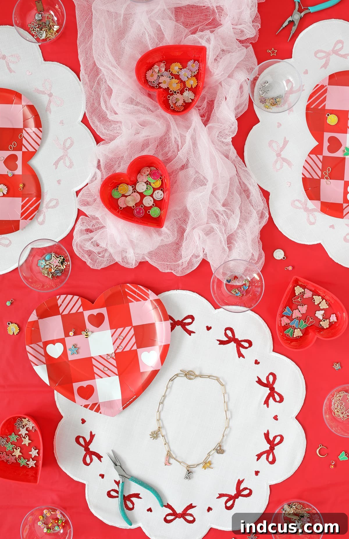 Tween girls enjoying their DIY charm necklaces at a Galentine's Day party setup with pink and red decor.