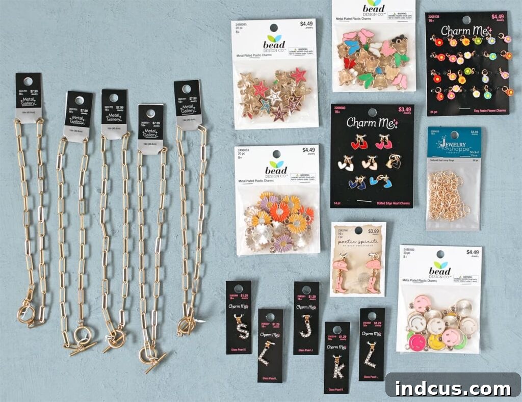 Supplies laid out for making DIY charm necklaces including chains, jump rings, and various charms.