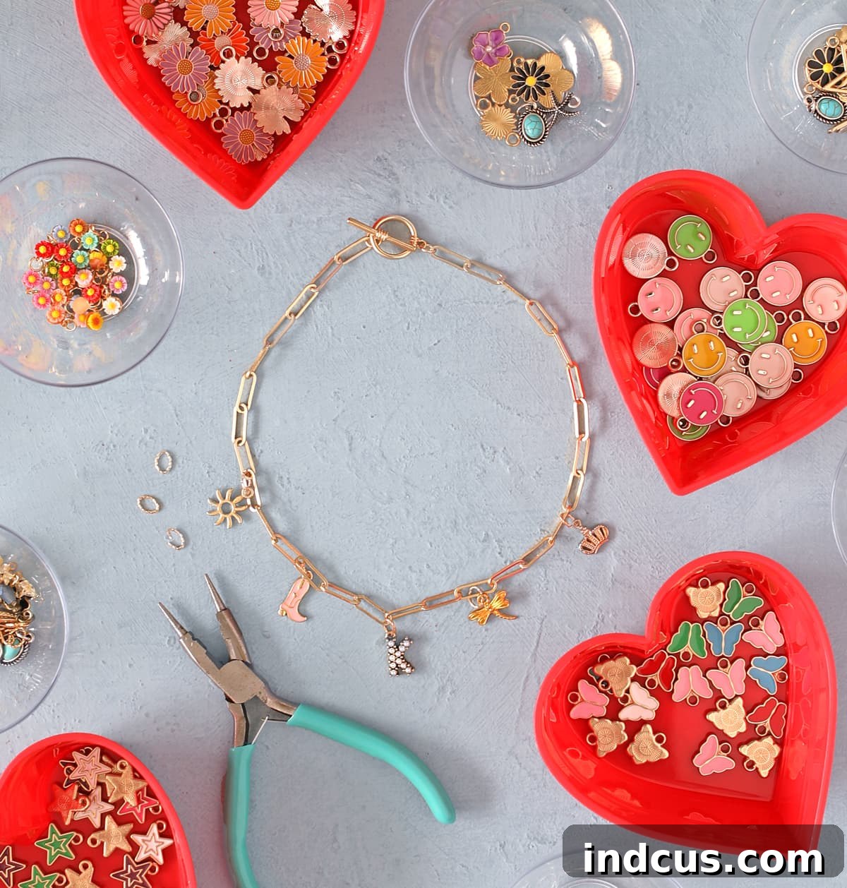 Close-up of a tween girl attaching a charm to a paperclip chain necklace with jewelry pliers.